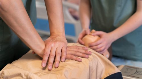 une personne faisant des gestes d'urgence sur un mannequin