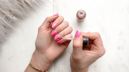 femme se mettant du verni à ongles