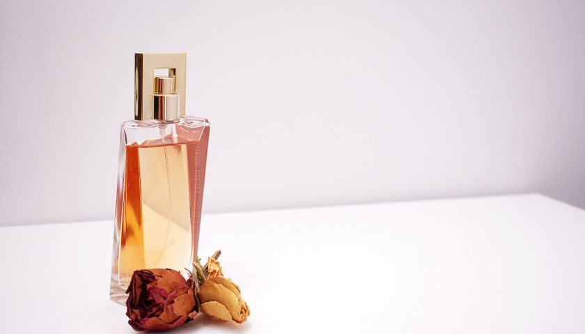 un flacon de parfum avec des roses
