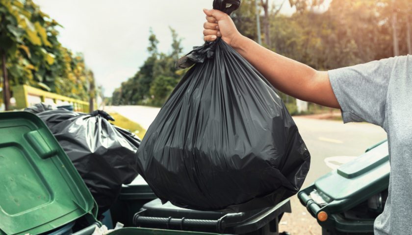 un homme jetant un sac poubelle