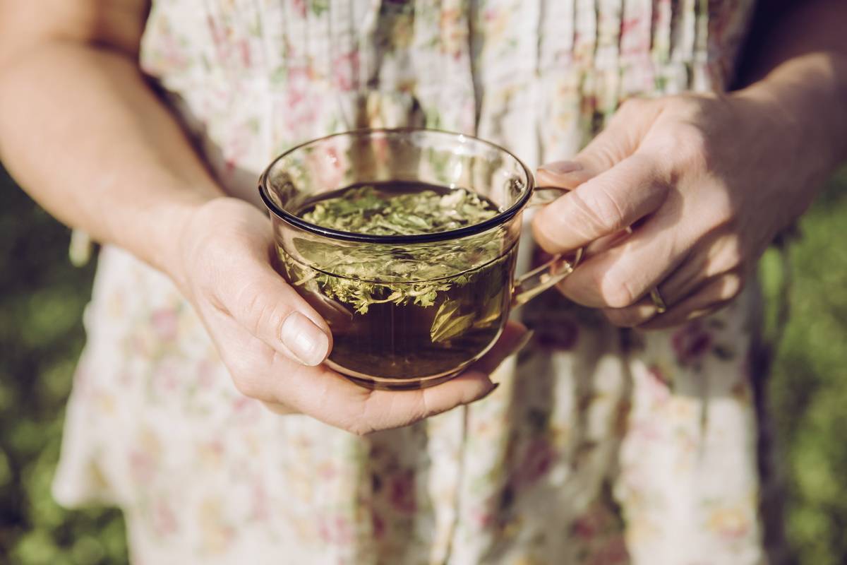 une femme tenantn une tisane dans sa main