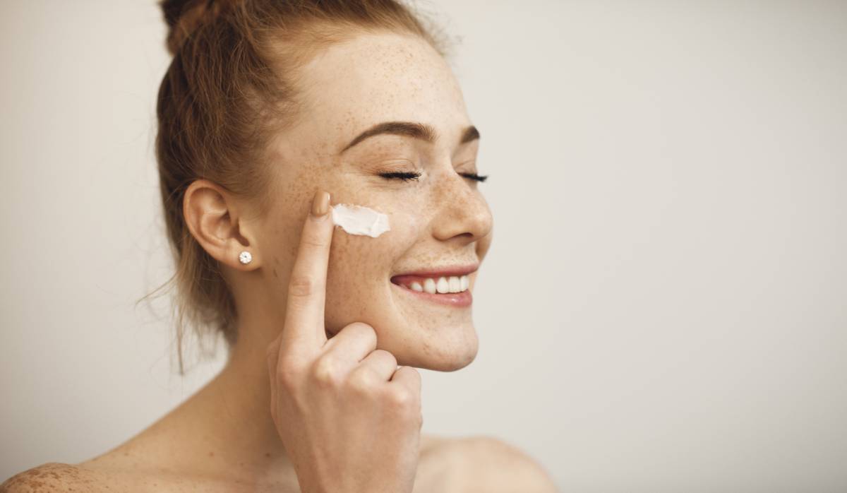 une femme appliquant des produits sur son visage