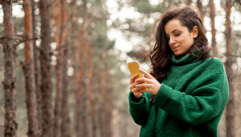 une femme sur son téléphone en foret