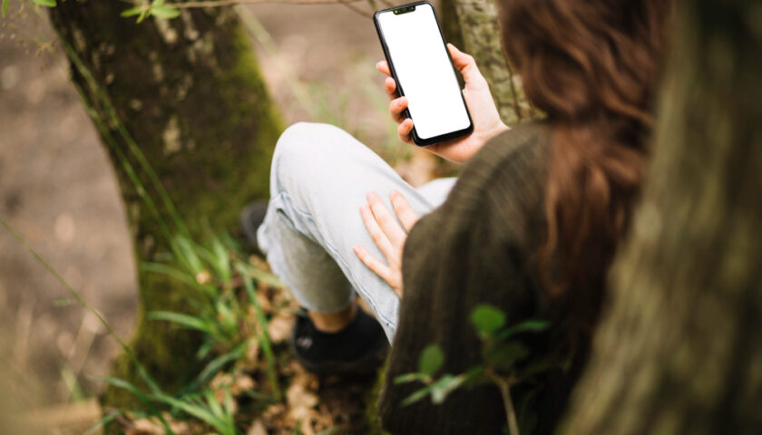 une femme sur son téléphone en foret