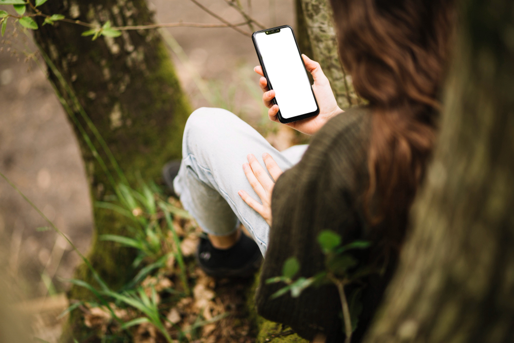 une femme sur son téléphone en foret